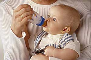 一位母亲在用奶瓶给宝宝喂奶